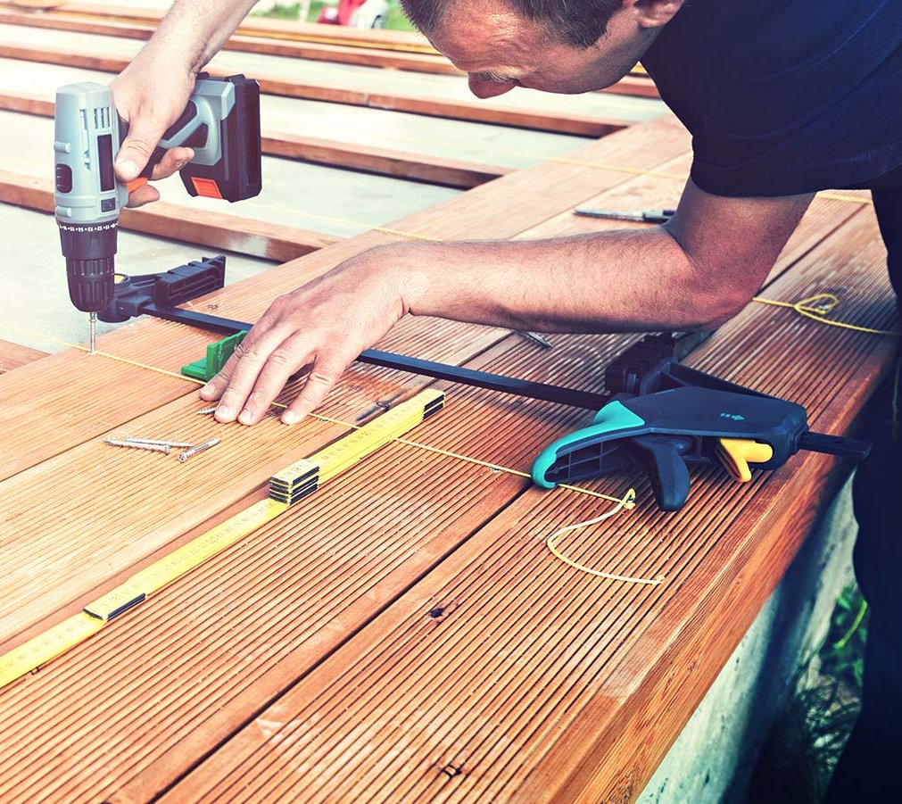 Handwerker verlegt Holzterrasse