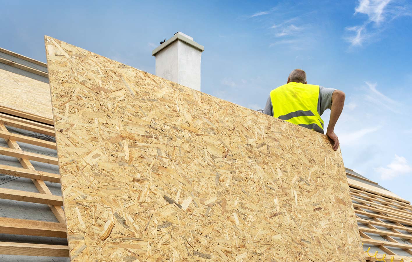 Mann auf Dach mit OSB-Platte