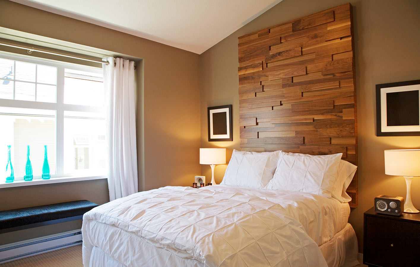 Blick in ein Schlafzimmer mit dunklen Holzpaneelen an der Wand